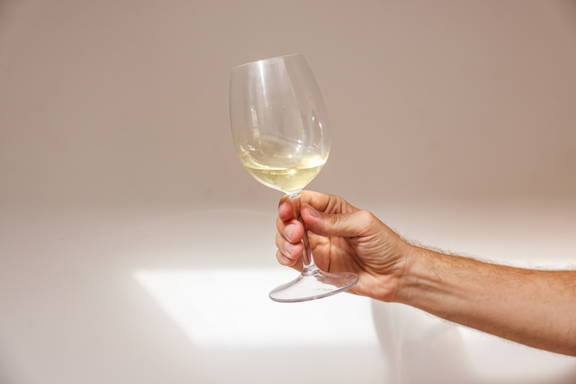 A white wine glass portraying the the importance of it to be smaller to maintain chill. 