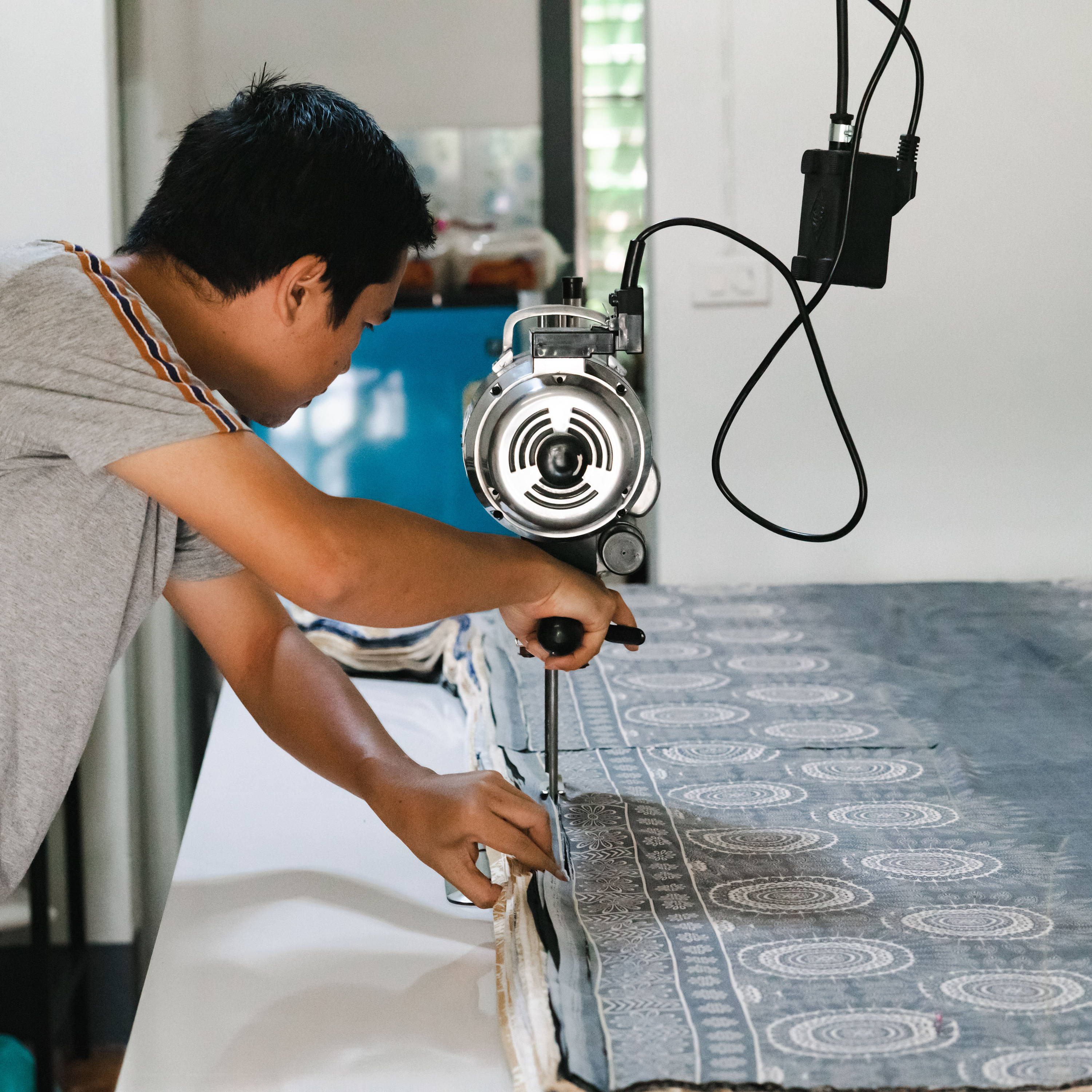 Man Cutting Printed Thai Fabric