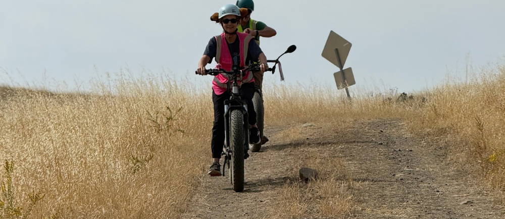 two people riding electric bikes on a dirt road in the sierra foothills, mariposa. photo: yosemite ebiking (yosemiteebiking.com)