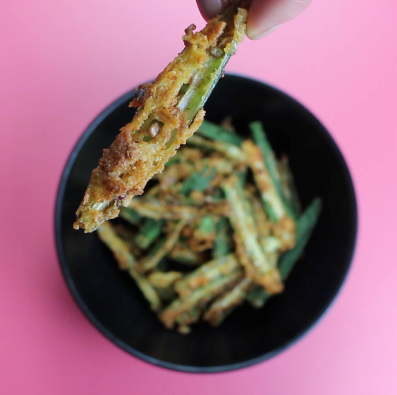 Crispy okra fries in a bowl covered in golden batter.