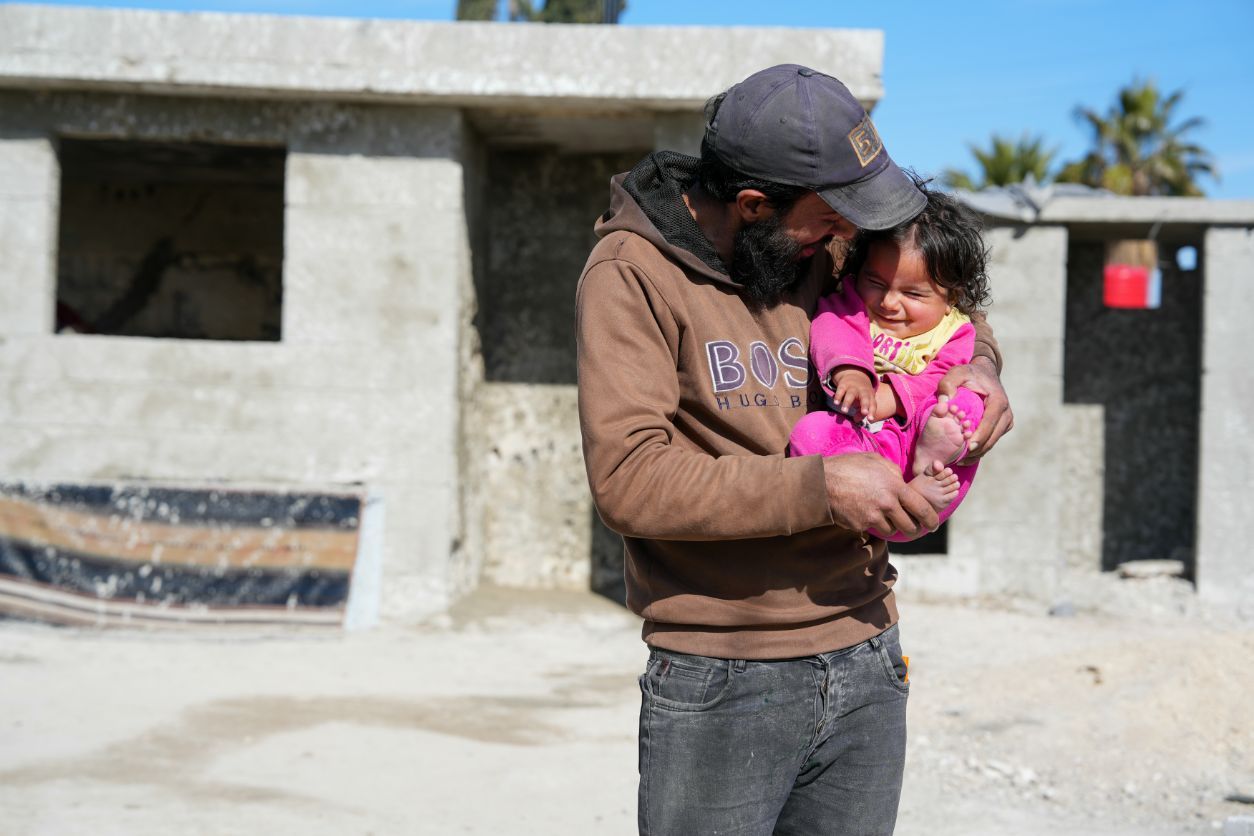 Tareq Alsaid (35) og niesen Aisha (1) utenfor Damaskus i Syria. De har vært på flukt og kommet hjem, får hjelp fra NRC.