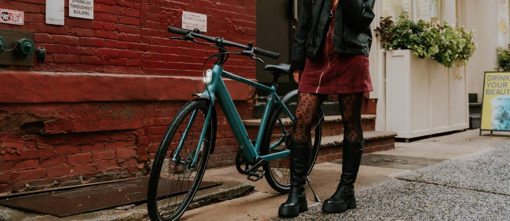 Woman standing next to Tenways hybrid electric bike