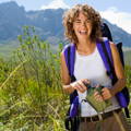 female hiker on hill holding water bottle and smiling happy_female_hiker_holding_water_bottle