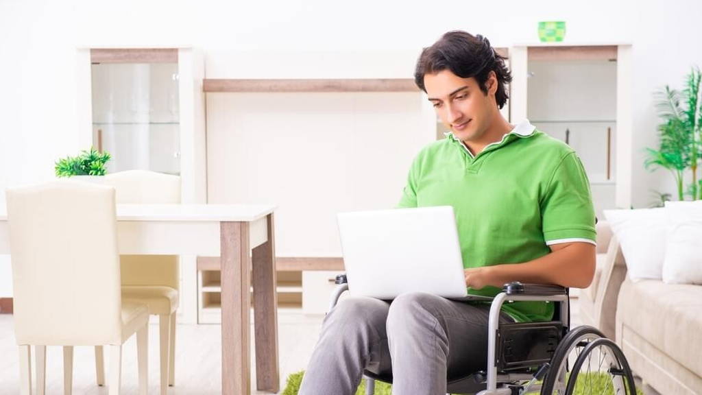 Young handsome man in wheelchair at home