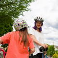 Mother and daughter out for a bike ride with Tozuda indicator attached to back of child's helmet.