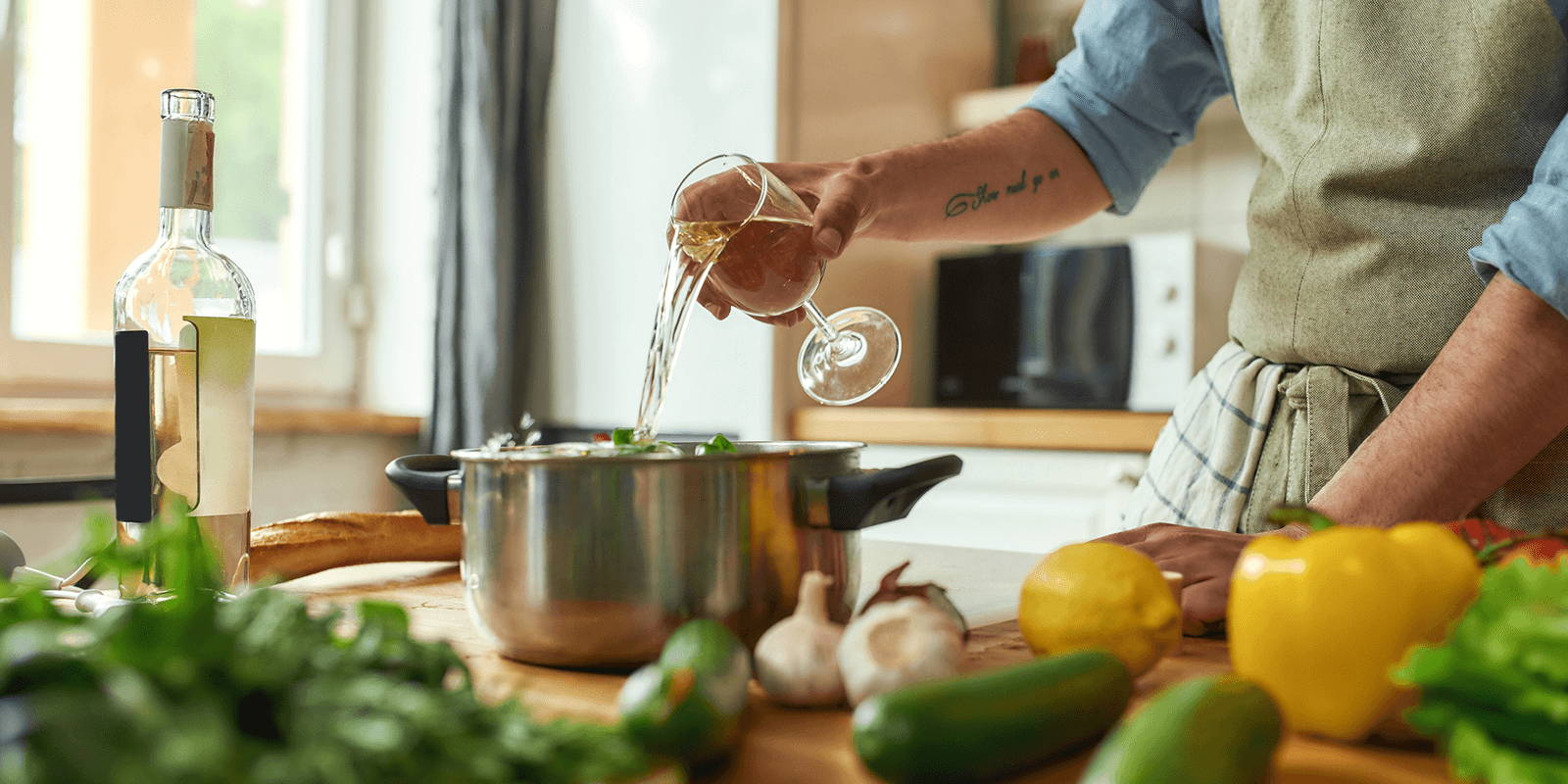 Cook pouring wine into a pot.