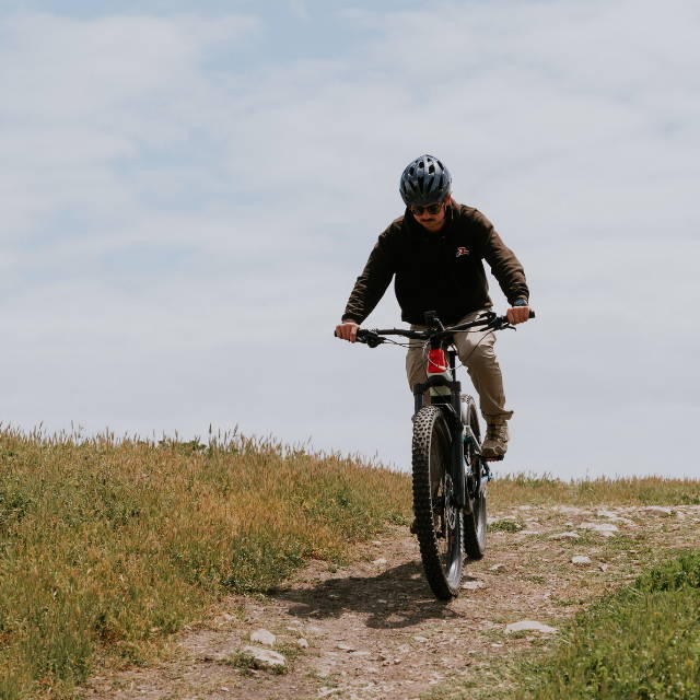 a man riding a red Cannondale Moterra electric mountain bike