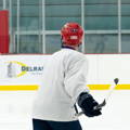 Hockey player on the ice with Tozuda indicator attached to back of red helmet.