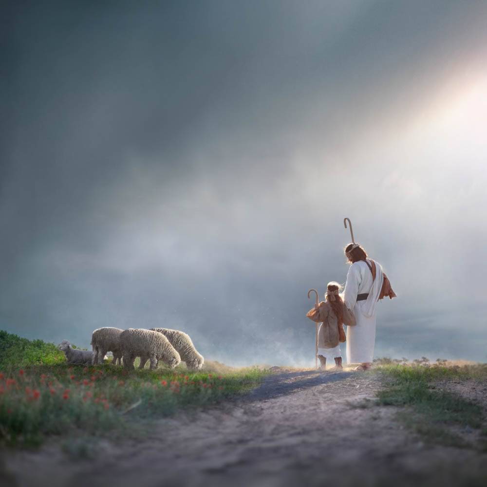 Jesus walking with a young shepherd down a dirt path past a group of sheep. 