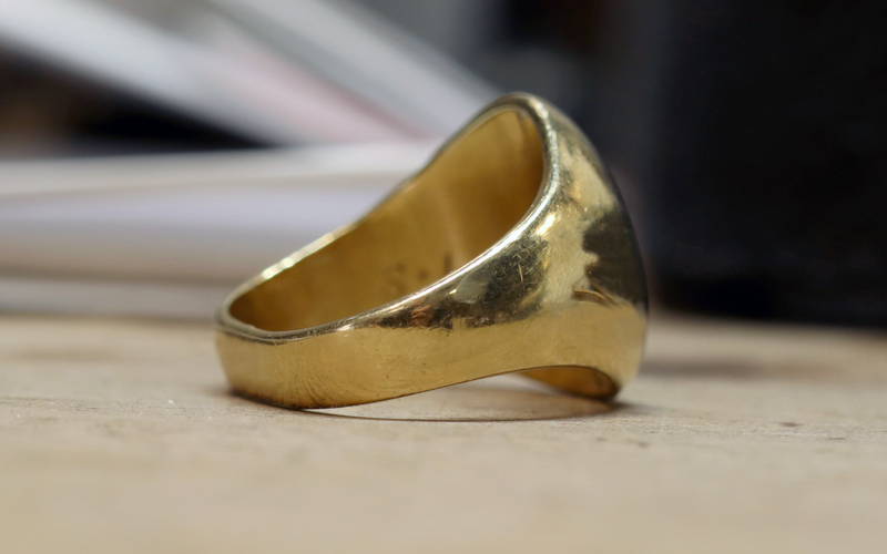 Gold ring with deformed ring body.
