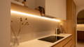 Bright yet calming LED lighting transforming a Newport QLD house with layered illumination across the kitchen