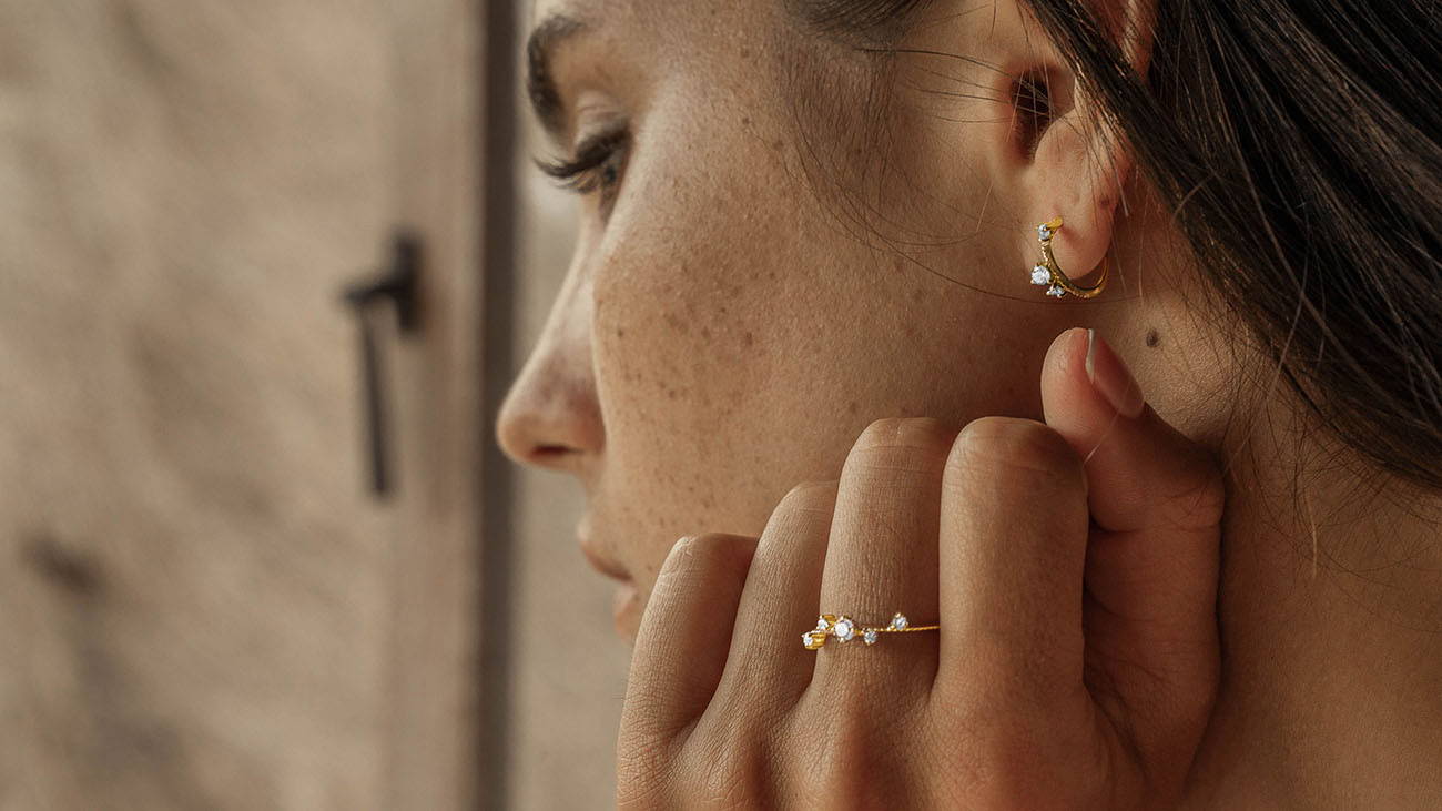 Woman wearing Scéona rings and earrings in a pensive mood