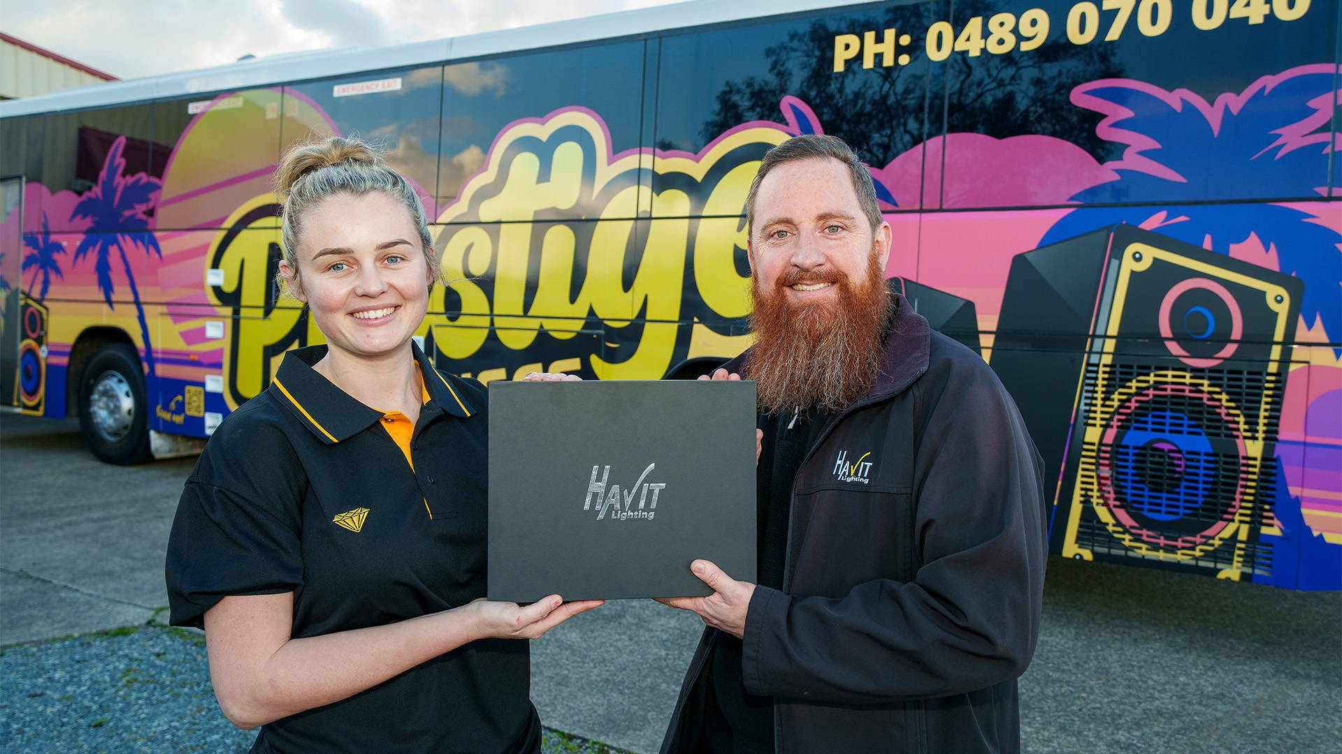 Havit Sales Rep presenting a promo box to the electrician and owner of the party bus