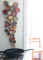 A vertical group of glass spice jars positioned from larger to smaller leading down to a cast iron skillet