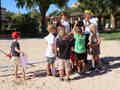 Eine Gruppe Kinder versammelt sich um zwei als Piraten verkleidete Erwachsene in einem sonnigen Außenbereich.