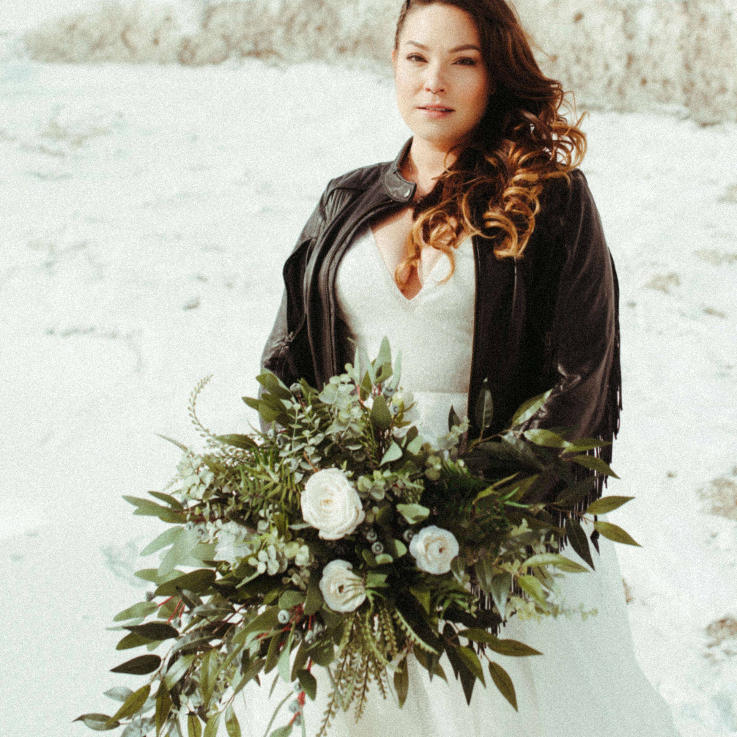 Oversized bridal bouquet with lush eucalyptus and greenery with white ranunculus and roses 