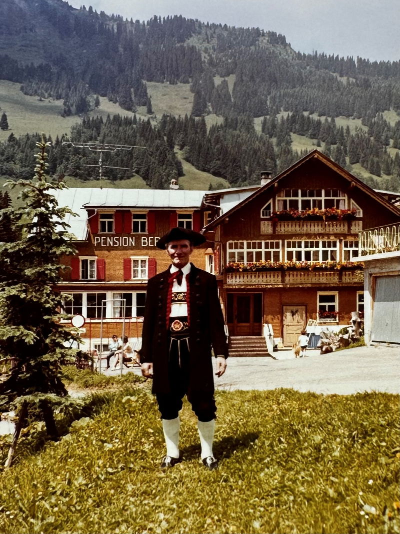 Opa Hugo in Tracht vor der Pension Bergidyll in Mittelberg im Kleinwalsertal.