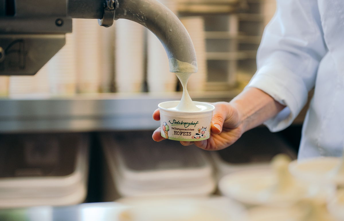 weißes Eis kommt aus Hahn in Papierbecher
