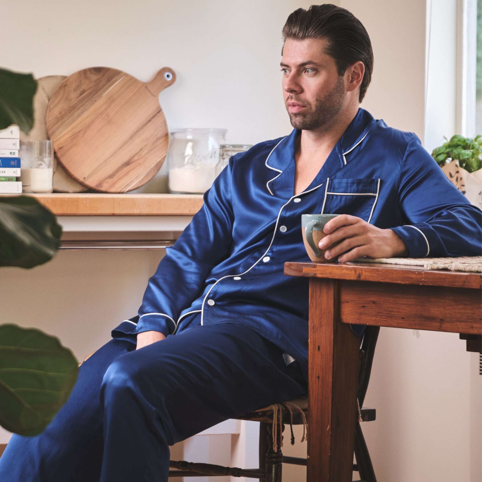 photo of a model drinking coffee and wearing midnight blue silk pajamas