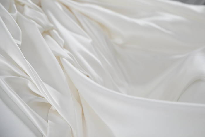 close up of a silk duvet cover being unfolded