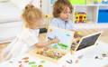 Brother and sister playing with Montessori Magnetic Circus Board in their playroom. 