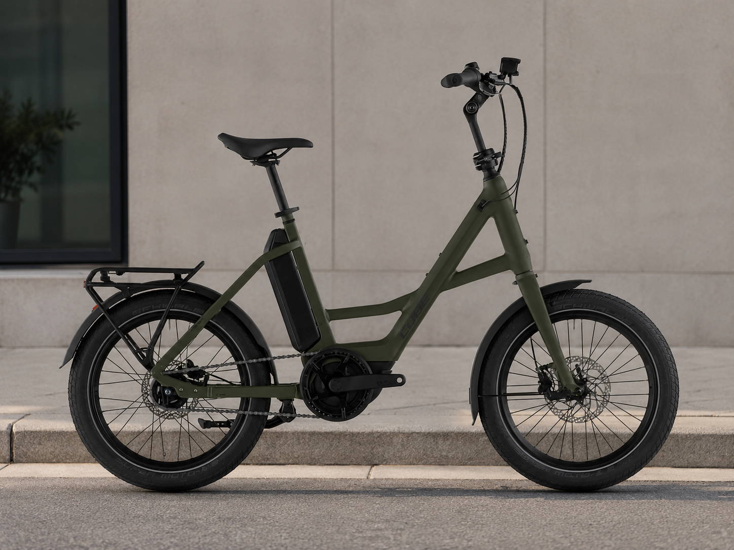 Cube Fold Hybrid Comfort elektrische vouwfiets in groen met bagagedrager, in een rustige stedelijke omgeving