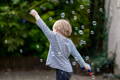 Little boy hopping, surrounded by bubbles.