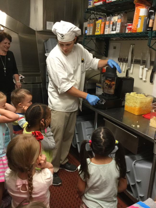Little Primrose students close their ears as they watch the chef make veggie and fruit smoothies in the noisy blender