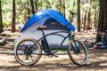 Un vélo électrique devant une tente de camping
