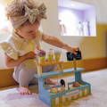 Toddler playing with a Montessori Ice Cream Shop.