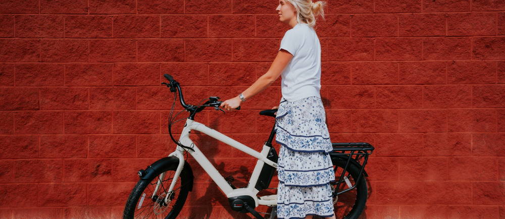 a woman standing next to a white Benno Boost electric cargo bike