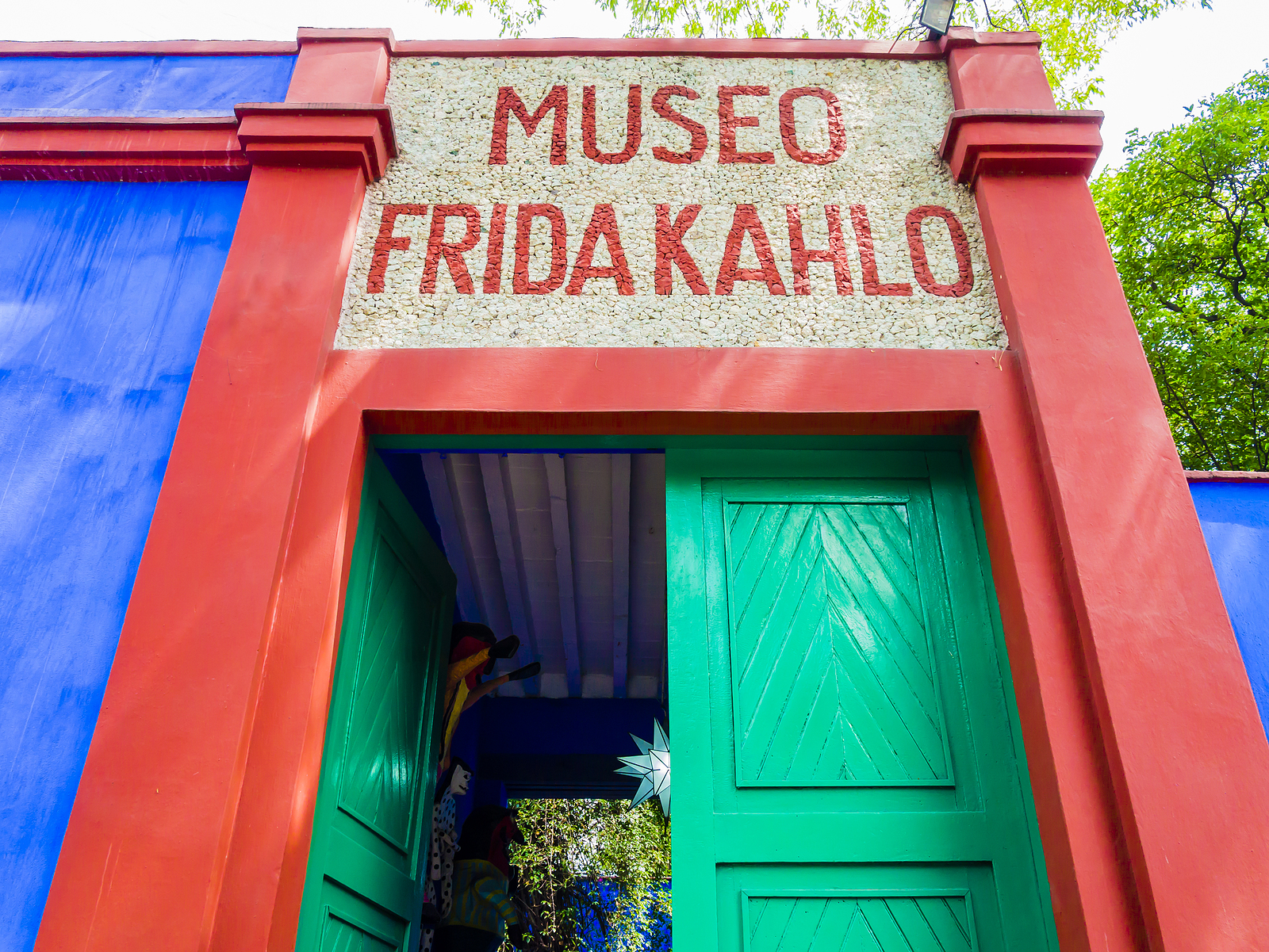 Frida's house, with large colorful doors and bright turquoise blue in color.