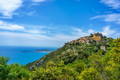 Vue d'un village perché sur une colline en bord de mer