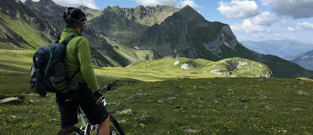 a mountain or electric mountain biker in a clearing below mountains
