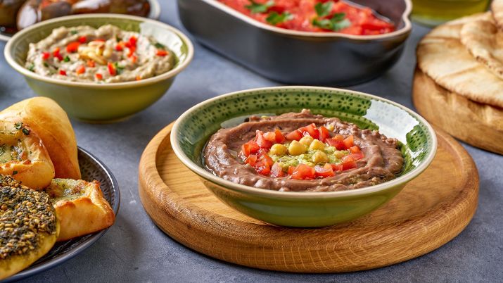 Fuul Medames, a hearty dish featuring cooked fava beans, often served with toppings