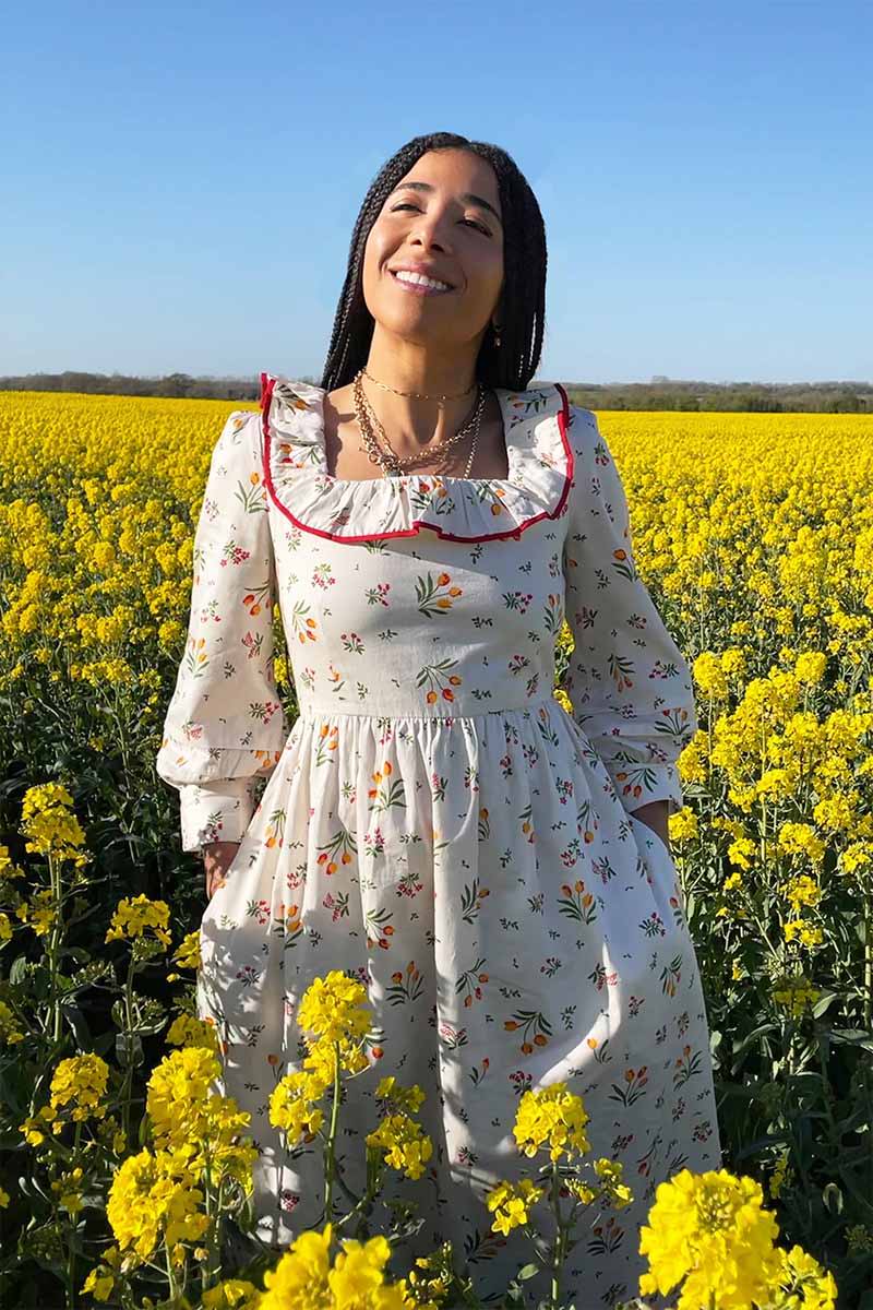 YOLKE's Tulip print Beatrice Dress with a red trimmed frill in a field of yellow flowers