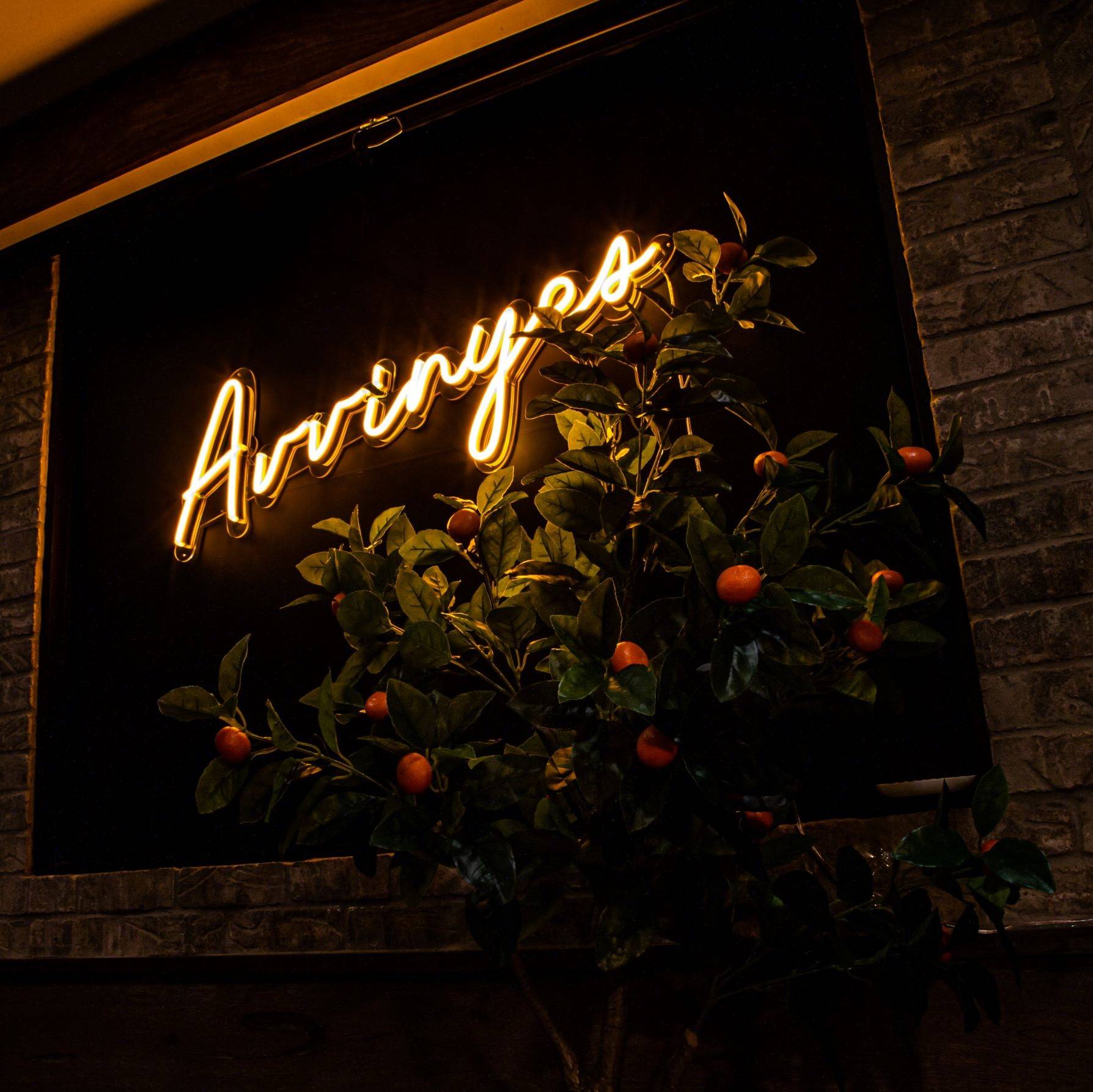 Avvinyes sign at avvino with everlasting orange trees
