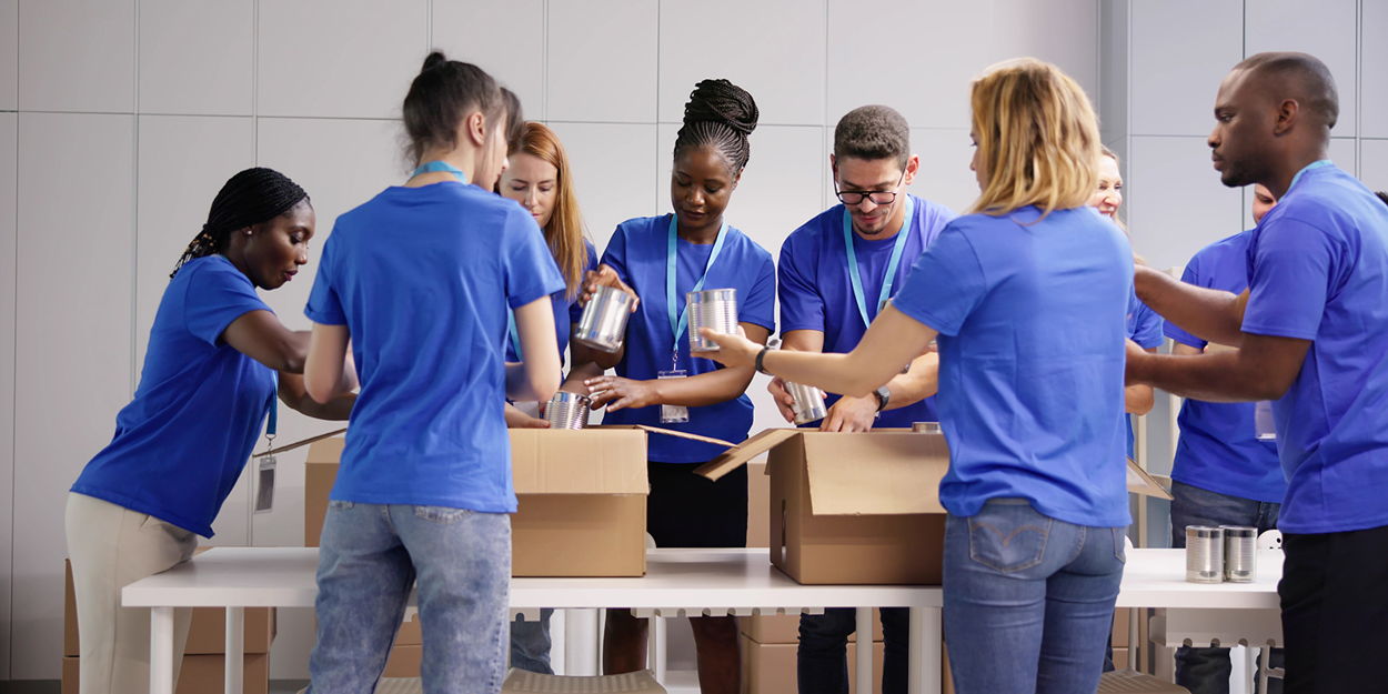 A corporate group packs food at a food bank
