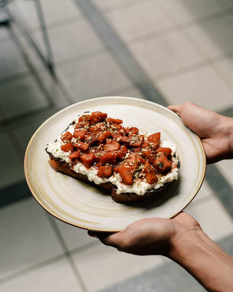 Plated breakfast food being held by a person
