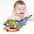 Baby boy laying on the ground, smiling and touching a Montessori Baby Cloth Book.