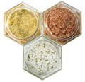 Three glass spice jars are filled with different flavored salts