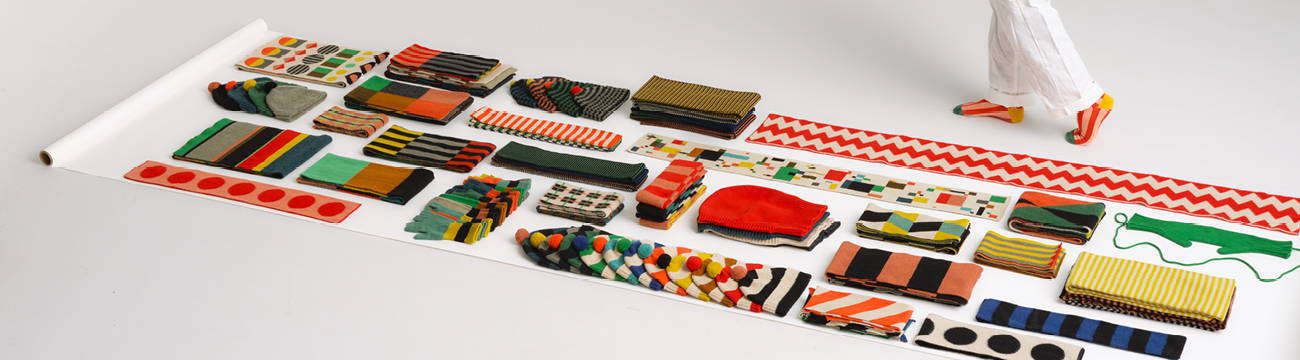 colourful Jo Gordon knitwear laid out on a roll of white paper