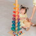 Little Asian girl playing with the Montessori Rainbow Tree.