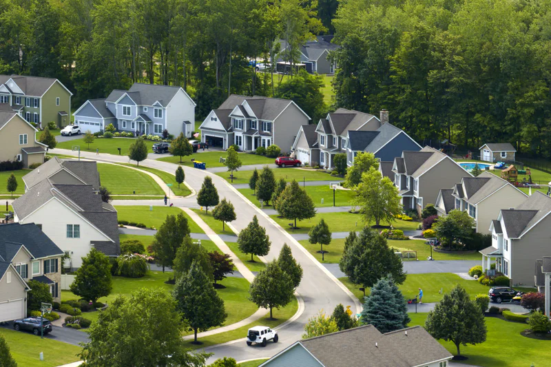 Suburban neighborhood with large lawns and a few trees