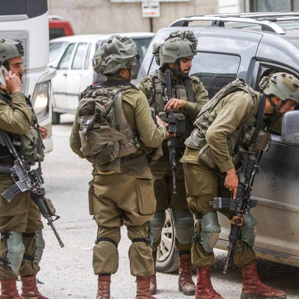 Israeli soldiers search Palestinian cars