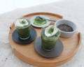 Garden matcha latte in a ceramic cup and honey and lavender on the side on a wooden tray