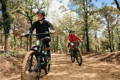 Deux personnes sur un sentier de forêt sur des VTT électriques
