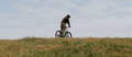 Man riding an electric mountain bike on grassy hill