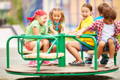 Group of kids having fun on a carousel. 