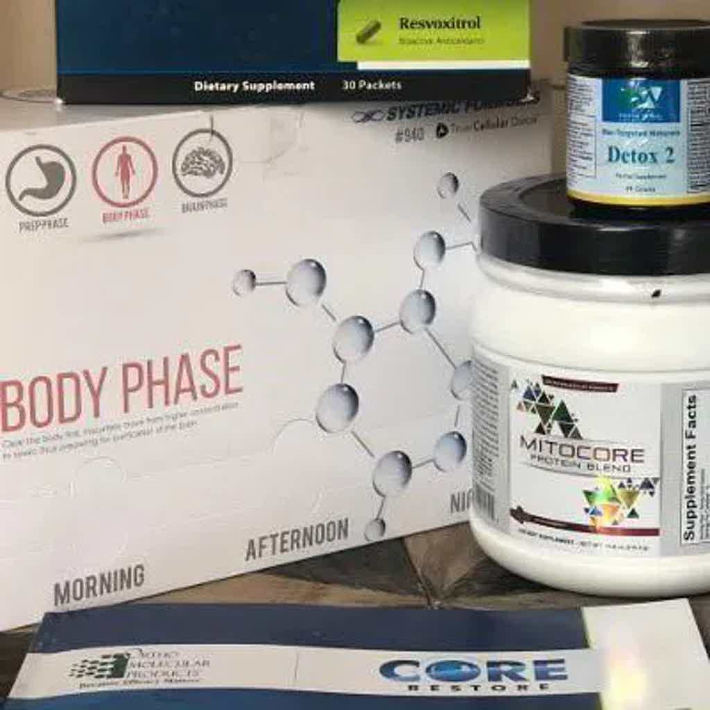 Supplement bottles and labels on table with “BODY PHASE” schedule, “ResVixtriol,” and “MICROCORE” products.